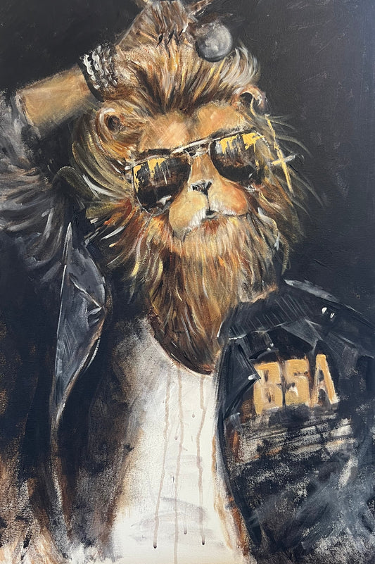 A square canvas painting of a lion wearing sunglasses and a black jacket with gold lettering, displayed on a wooden surface.
