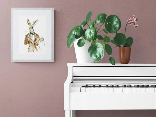 Whimsical jazz singer hare art print framed above white piano